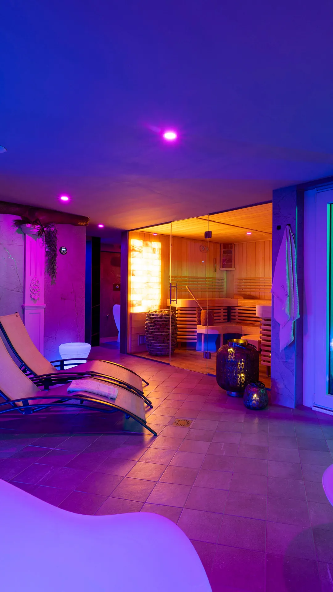 Espace détente de Dune Spa avec transats, sauna vitré en arrière-plan